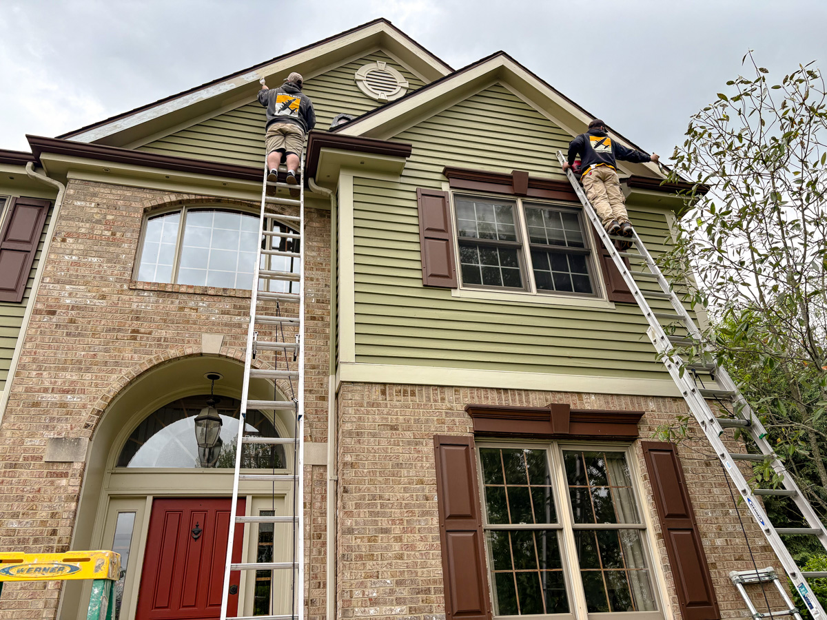 Bombardier painters painting the fascia of a high-end home
