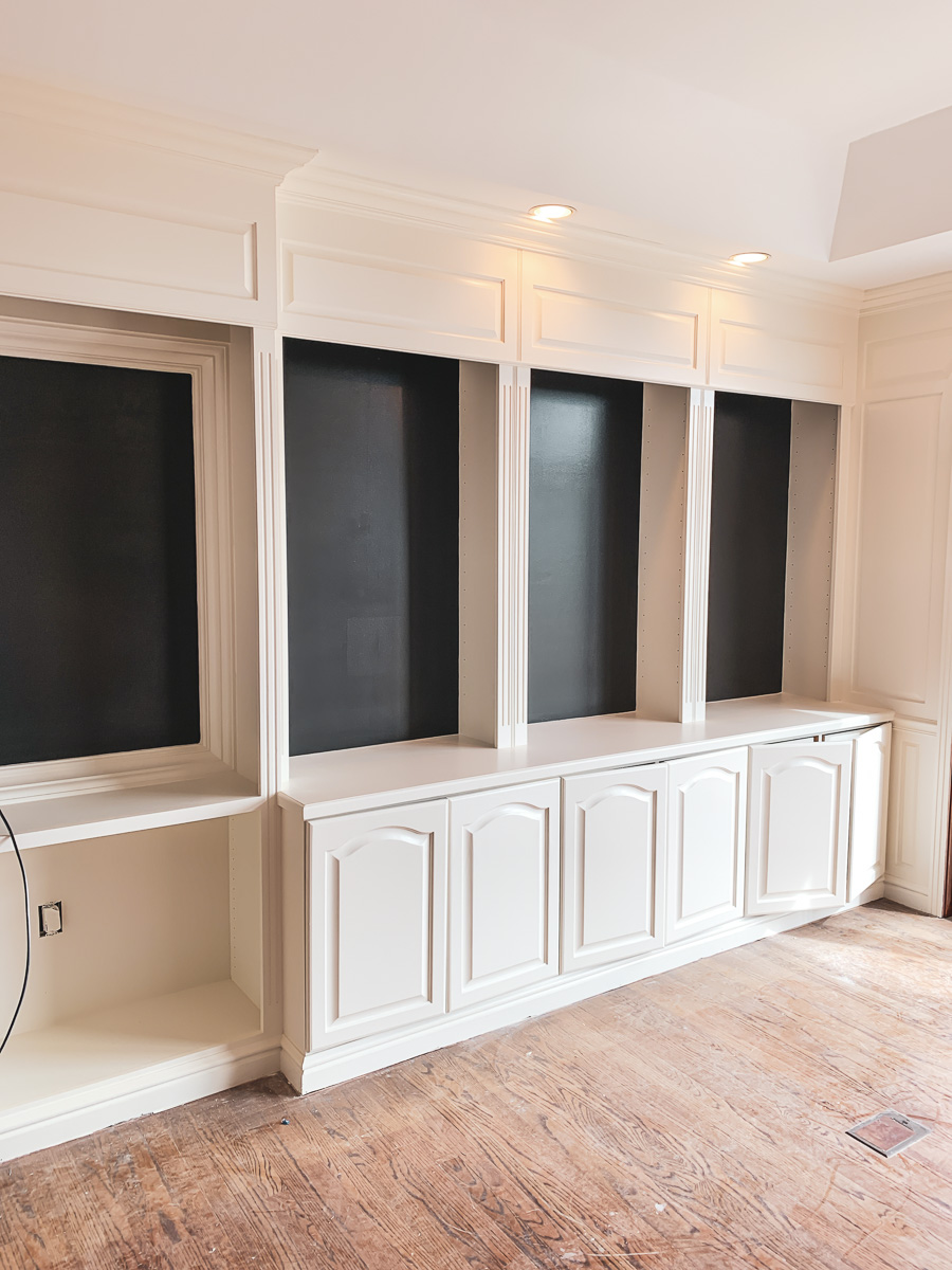 A set of cabinets and shelves revealing a painted wall behind